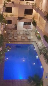 an overhead view of a large blue pool with chairs and umbrellas at Costa Miramar in Acapulco