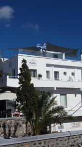 a large white building with a blue sky at Platia in Fira