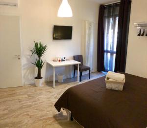 a bedroom with a bed and a table and a desk at CITYHOUSE in Padova