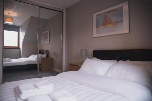 a bedroom with a large white bed and a mirror at Townhouse on the Spital in Aberdeen