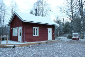 Cabaña roja pequeña con techo cubierto de nieve en Villa Orohat 1, en Rovaniemi