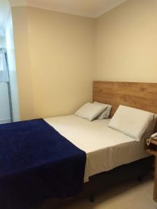 a bedroom with a bed with a blue and white sheets at Hotel Saint Lucas in São Paulo