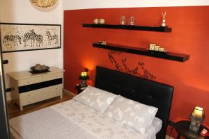 クアルトゥ・サンテーレナにあるSandan Homeの赤い壁のベッドルーム1室(ベッド1台付)