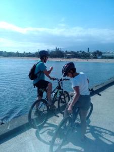 a man and a woman riding bikes by the water at Corail Azur Terre Sainte in Saint-Pierre