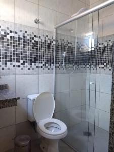 uma casa de banho com um WC e uma cabina de duche em vidro. em Hotel Saint Lucas em São Paulo