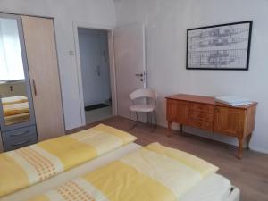 Un dormitorio con dos camas y un escritorio y una silla. en Apartment Meschnik, en Graz