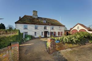 una gran casa blanca con techo de hierba en Haughley House en Stowmarket