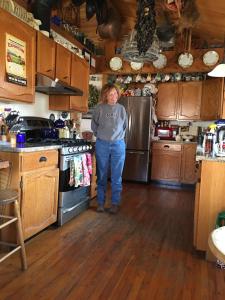 um homem de pé numa cozinha com um frigorífico em Canyon Wren Bed and Breakfast em Lake Bluff