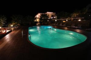 - une grande piscine la nuit dans l'établissement Tholos Bay Suites, à Kavoúsion