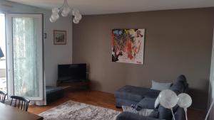 uma sala de estar com um sofá azul e uma televisão em Très bel appartement centre ville 2 mn plages et marché em Dinard