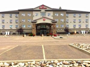 a hotel with a parking lot in front of it at Ramada by Wyndham Lac La Biche in Lac La Biche