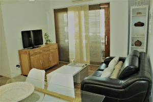 クアルトゥ・サンテーレナにあるSandan Homeのリビングルーム(黒い革張りのソファ、テレビ付)