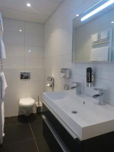 a bathroom with a white sink and a toilet at Studio's de Domburger in Domburg