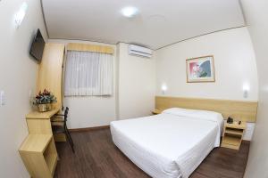ポルト・アレグレにあるHotel Express Centro Históricoのベッドと机とテレビのある寝室