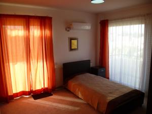 a bedroom with orange curtains and a bed and a window at Private deluxe room with balcony at Datacom building in Nicosia