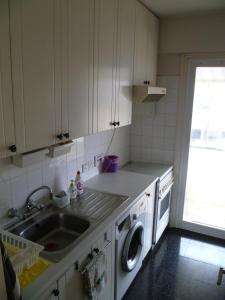 a kitchen with a sink and a washing machine at Private deluxe room with balcony at Datacom building in Nicosia