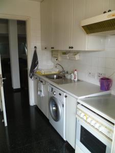 a kitchen with a sink and a washing machine at Private deluxe room with balcony at Datacom building in Nicosia