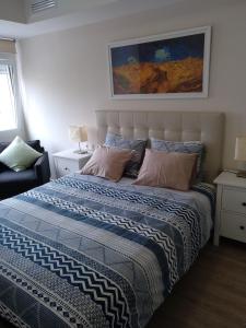 1 dormitorio con 1 cama grande con sábanas azules y blancas en RUZAFA CENTRO AIRE ACONDICIONADO WiFi en Valencia