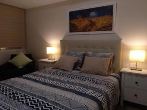 RUZAFA CENTRO AIRE ACONDICIONADO WiFi في فالنسيا: غرفة نوم بها سرير مع مصباحين