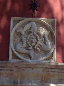 a statue of two women on a wall at Villa Astoria in Taormina
