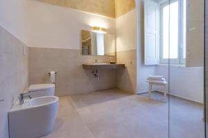 a white bathroom with a sink and a toilet at Palazzo Cariddi Apartment in Nardò +84 photos