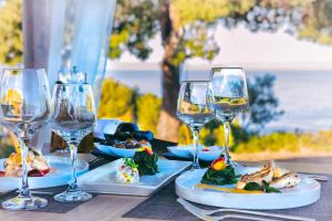 a table with two plates of food and wine glasses at Heos Accommodation in Ormos Panagias