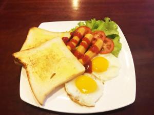 a plate of breakfast food with eggs and toast at Lucky Hostel in Battambang