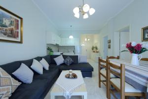 a living room with a black couch and a table at Kefalas Apartments in Parga +78 photos