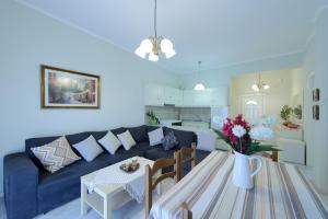 a living room with a blue couch and a table at Kefalas Apartments in Parga