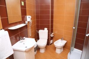 a bathroom with two toilets and a sink and a shower at Hotel Crystal Palace in Râmnicu Vâlcea +11 photos