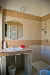 ein Bad mit einem Waschbecken, einem Spiegel und einer Dusche in der Unterkunft san nicola d'amare in Bari