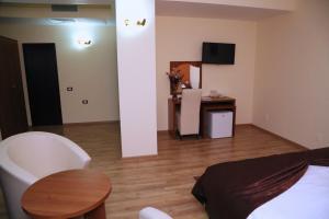 a living room with a bed and a table at Hotel Crystal Palace in Râmnicu Vâlcea