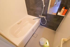 La petite salle de bains est pourvue d'une baignoire et d'une douche. dans l'établissement kyowara Tenjin / Vacation STAY 6821, à Kyoto