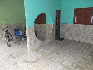 a room with a table and chairs and a bike at Pedacinho do Toque in São Miguel dos Milagres