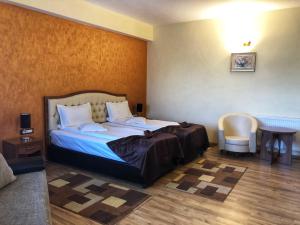 a bedroom with a bed and a table and a chair at Hotel Crystal Palace in Râmnicu Vâlcea