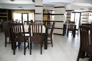 a dining room with a table and wooden chairs at Hotel Crystal Palace in Râmnicu Vâlcea