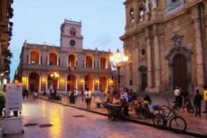 a large building with a clock tower in front of it at La Locanda in Marsala