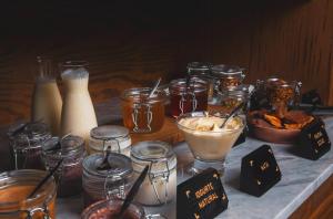 a table topped with jars of food and other foods at Wood Hotel in Gramado