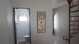 ein Bad mit einem WC und einem Bild an der Wand in der Unterkunft Loft Holambra in Holambra