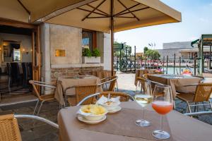 a table with two glasses of wine and food on it at Hotel Antiche Figure in Venice