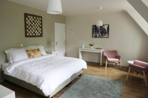 een slaapkamer met een bed, een bureau en een stoel bij Villa Helena in Linden