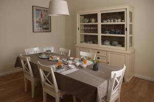 un comedor con una mesa con sillas y una cabaña en Villa Helena en Linden