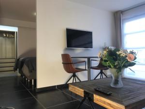 a living room with a vase of flowers on a table at Het Kleinste Hof in Geraardsbergen