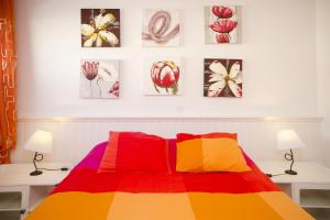 ein Schlafzimmer mit einem farbenfrohen Bett mit vier Bildern an der Wand in der Unterkunft Los Topes in Puerto del Carmen