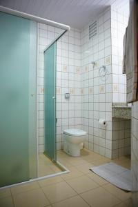 uma casa de banho com um WC e uma cabina de duche em vidro. em Hotel Estação 101 - Brusque em Brusque