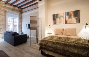 a bedroom with a bed and a couch in it at Beautiful loft in old town in Alicante