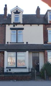 een stenen huis met ramen en een deur bij Quality Accommodation in Leeds