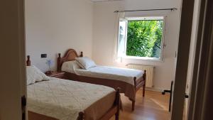 ein Schlafzimmer mit zwei Betten und einem Fenster in der Unterkunft Villa spacieuse proche de L'océan in Vila Praia de Âncora