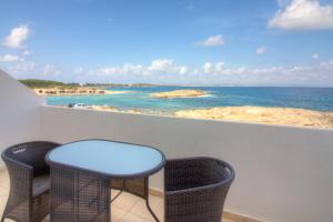 a balcony with two chairs and a view of the ocean at Hotel Roca Bella in Es Pujols