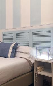 a bedroom with a bed with blue shutters at Raffaelli Villino Limoni in Forte dei Marmi